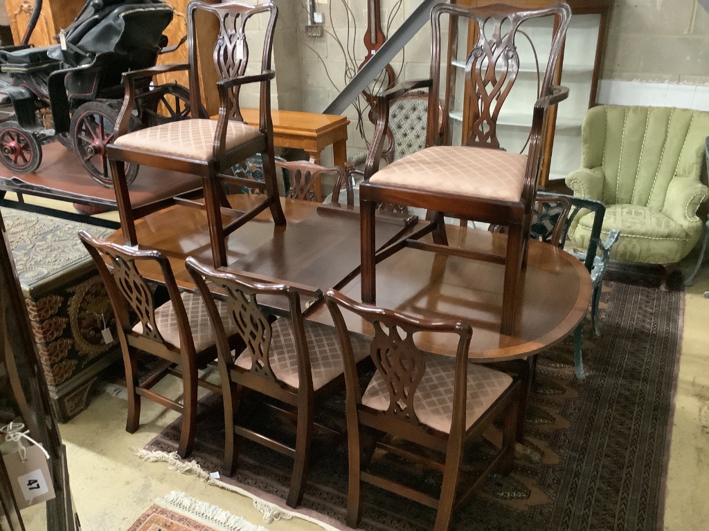 A George III style D-end twin-pedestal dining table and a set of eight George III style mahogany dining chairs, two with arms, table width 245cm extended (two spare leaves)